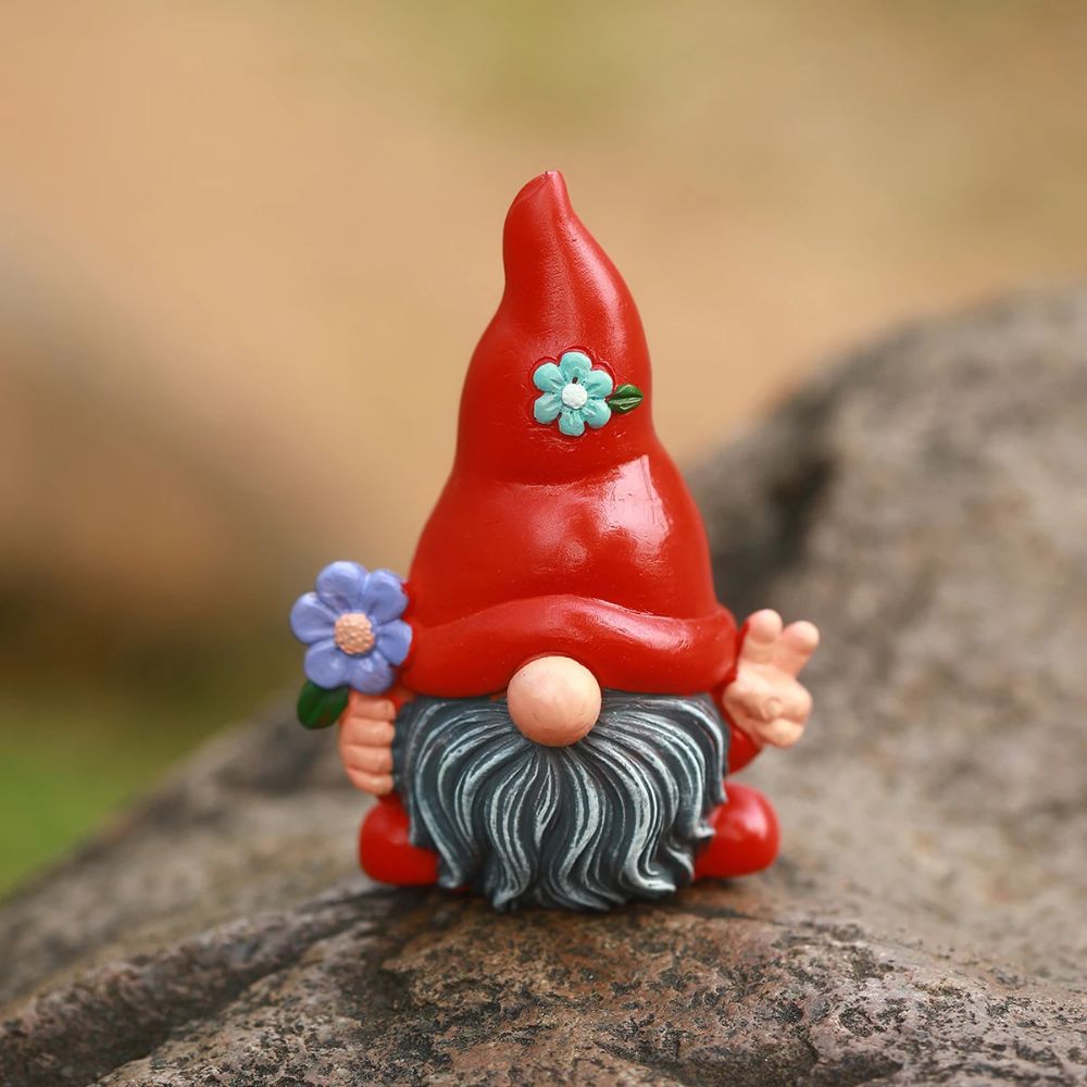 Nain de jardin de couleur rouge avec une fleur à la main